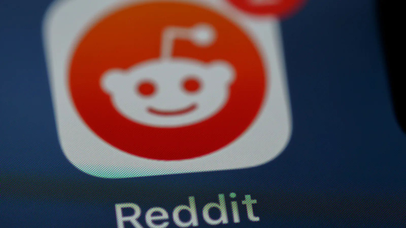 Krupan kadar ikone aplikacije Reddit na zaslonu pametnog telefona s crvenom obavijesti.