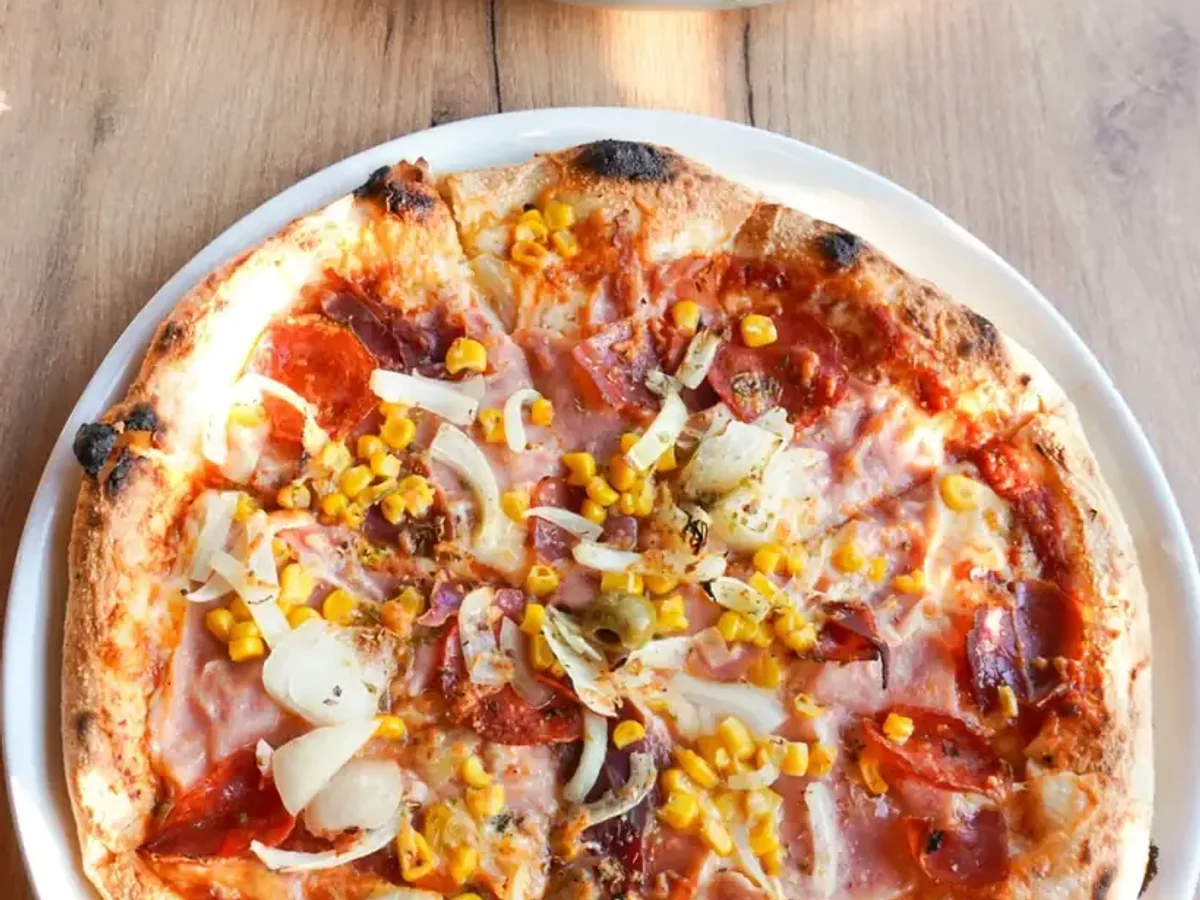 Pizza i posluženo glavno jelo na restoranskom stolu