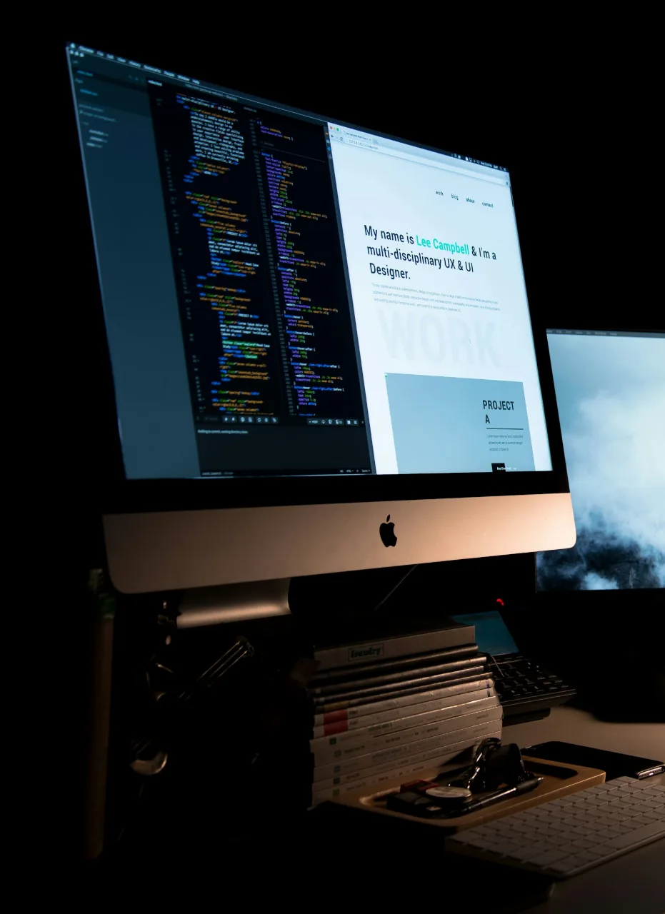 Razvojno okruženje s kodom i pregledom web-stranice na velikom monitoru.