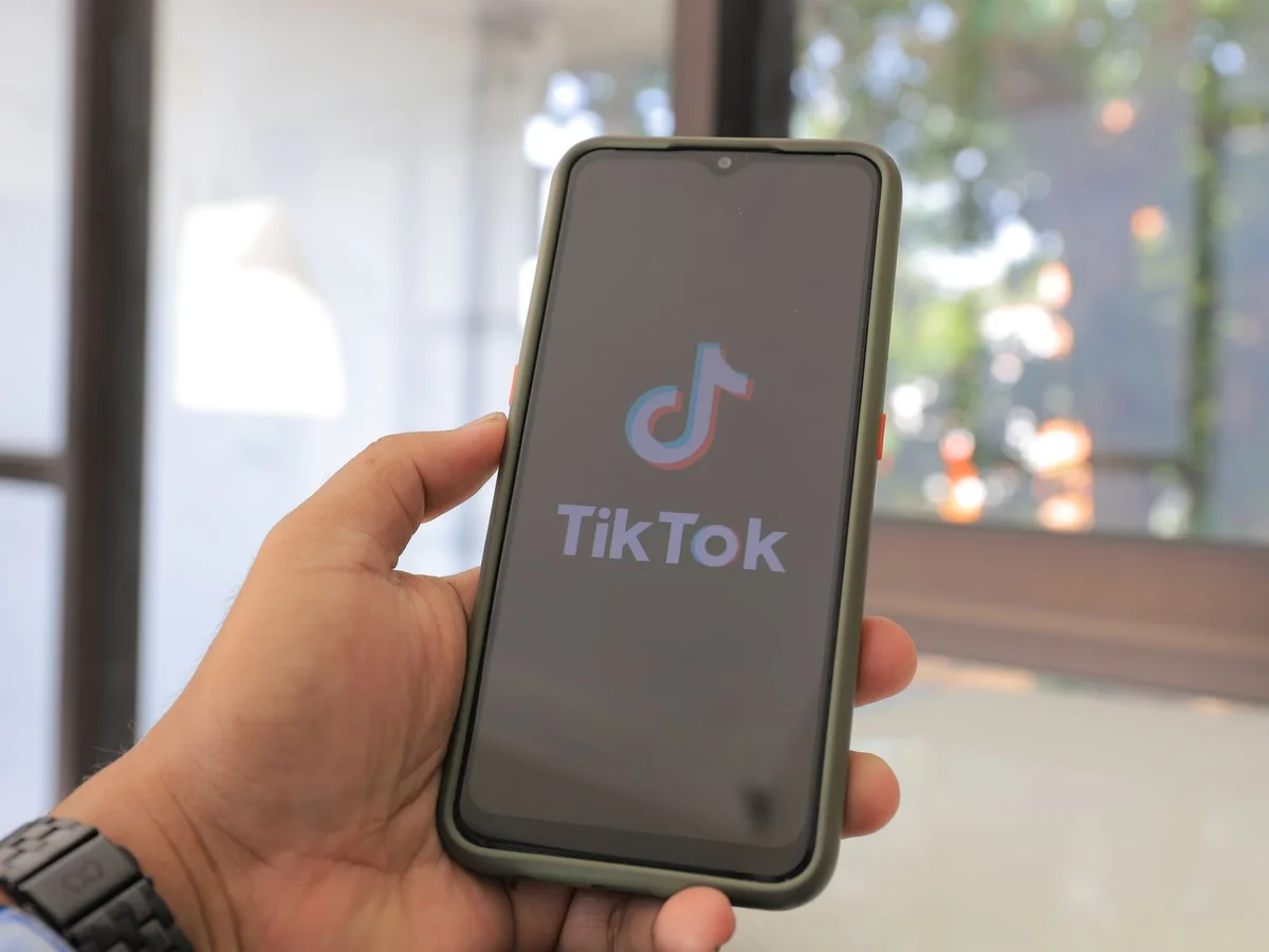Ruka drži pametni telefon s TikTok aplikacijom